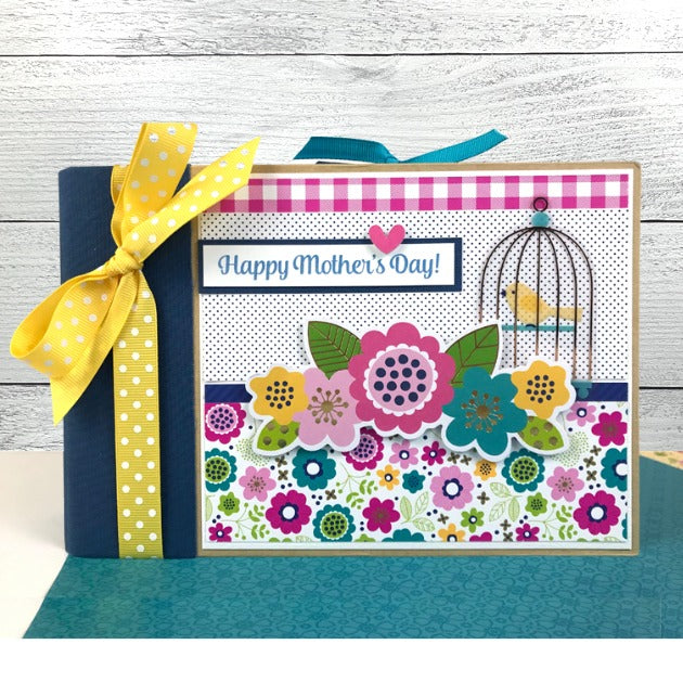 Mother's Day Scrapbook Mini Album with colorful flowers, gold foil accents, a birdcage, and a pretty yellow ribbon