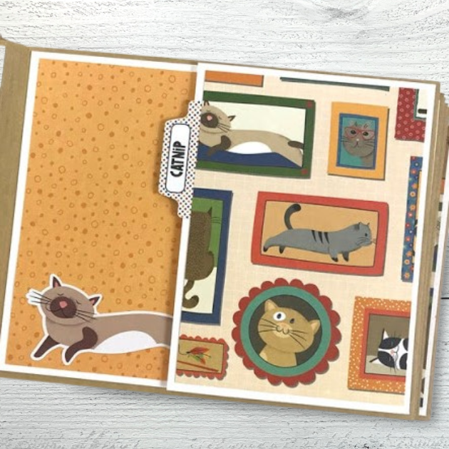 Cat scrapbook mini album page with framed cat photos and a folding page