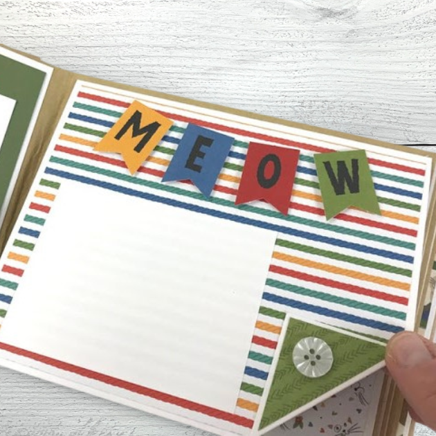 Cat scrapbook mini album page with a cute meow flag banner, colorful stripes, and a button