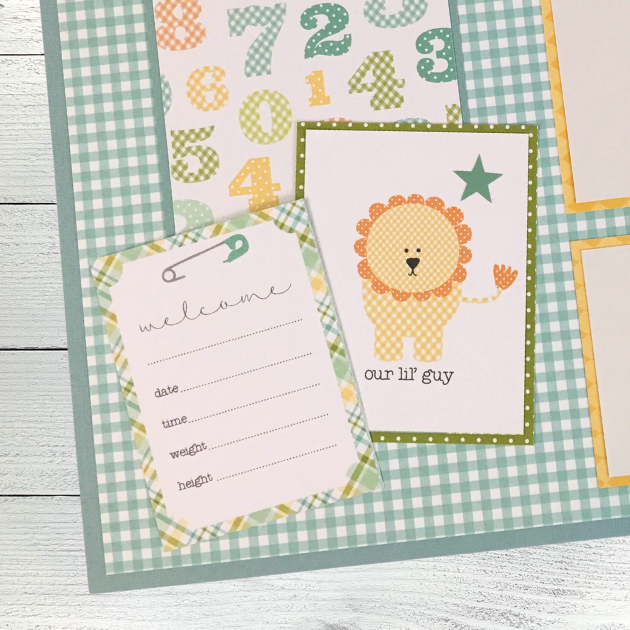 12x12 It's A Boy Baby Scrapbook Page Layout with colorful numbers, a journaling card with a safety pin, a cute lion, and a green gingham paper