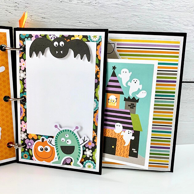 My Favorite Monsters Halloween Scrapbook Mini Album Page with colorful stripes, silly monsters, ghosts, a bat, a haunted house, and whimsical flowers