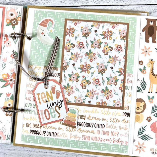 Twinkle Twinkle Baby Girl Scrapbook Album Page with flowers, a moon, toys, footprints, and a tag with ribbon