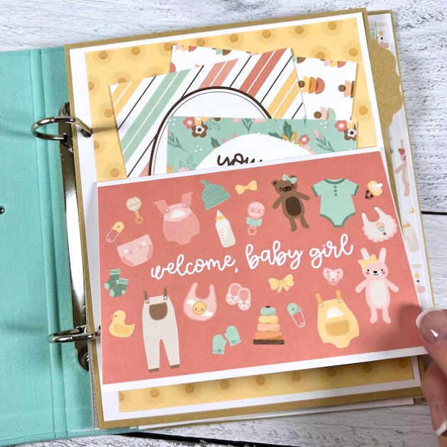 Twinkle Twinkle Baby Girl Scrapbook Album Page with cute toys and clothes, a pocket, and journaling cards