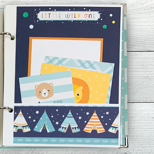 Hello Baby Boy Scrapbook Mini Album Page with a pocket, cute journaling cards, tepees, a lion, a bear, stars, and enamel dots