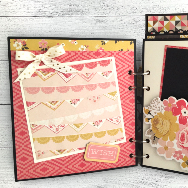 Time To Celebrate Scrapbook Mini Album Page with a polka dot bow, flag banners, flowers, and a geometric pattern 