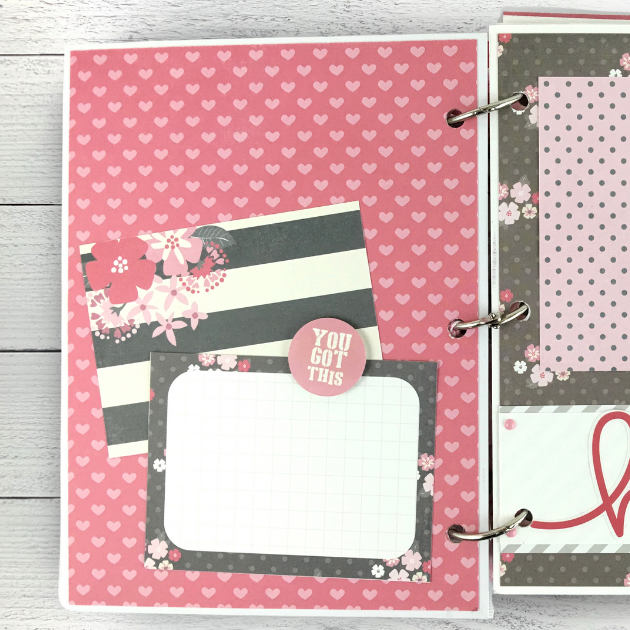 Breast cancer themed scrapbook mini album page with pink hearts, flowers, and a journaling card