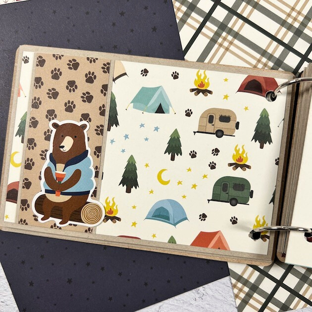 Adventure Awaits Scrapbook Mini Album Page with a cute bear, camper, paw prints, campfire, tents, trees, and stars