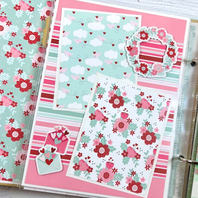 Love is All You Need Scrapbook Album Page with hearts, flowers, clouds, paper airplanes, and envelopes