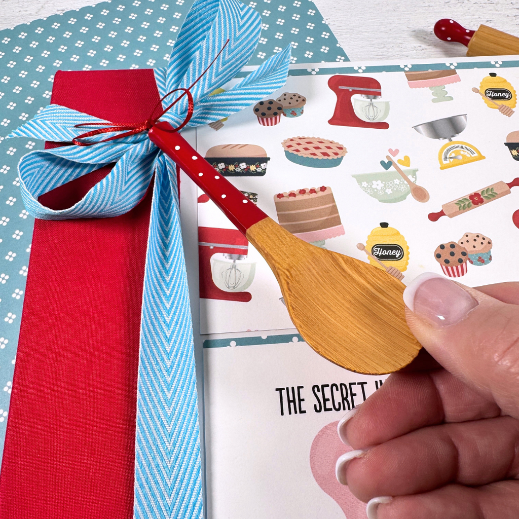 Recipe Scrapbook Mini Album with ribbon, a wooden spoon, bright colors, food, flowers, and fun kitchen items