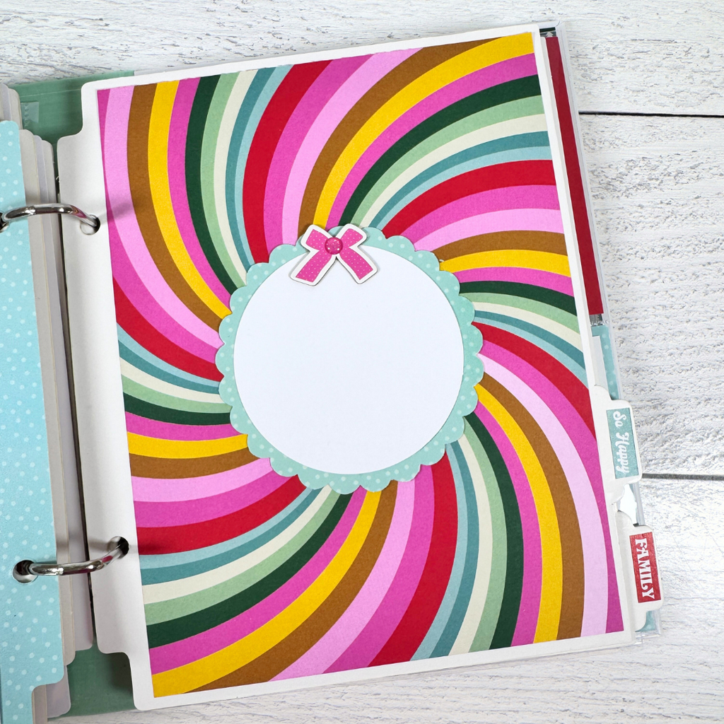 Christmas 25 Scrapbook Mini Album Page with colorful swirl stripes, a scalloped photo mat, and a tiny pink bow