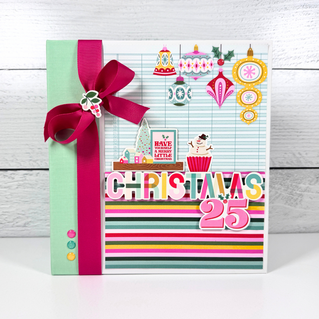 Christmas 25 Scrapbook Mini Album with pretty ornaments, a snowman cupcake, colorful stripes, and a big pink bow
