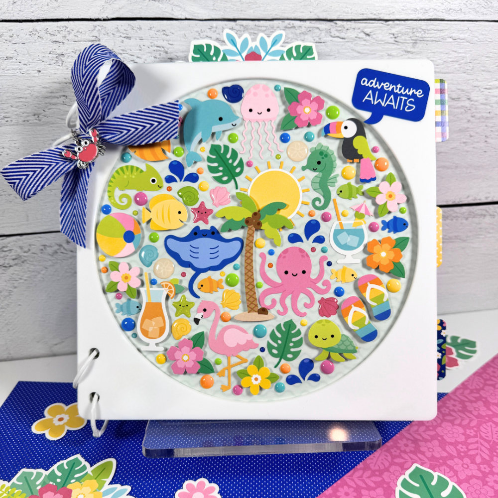 Adventure Awaits Summer Fun Mini Album with seashells, beach items, flowers, sand castles, and cute sea creatures displayed on a clear acrylic stand