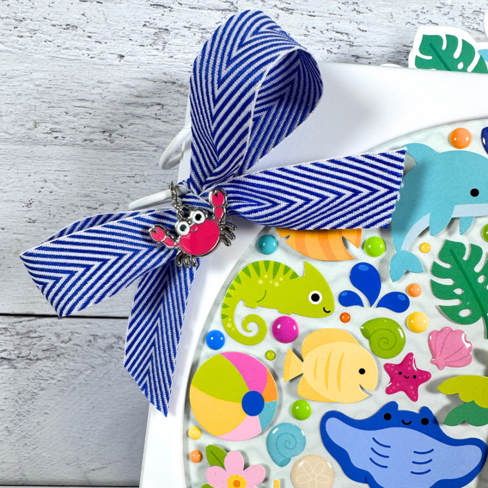 Adventure Awaits Summer Fun Mini Album with a bow, a cute red crab charm, and lots of colorful stickers