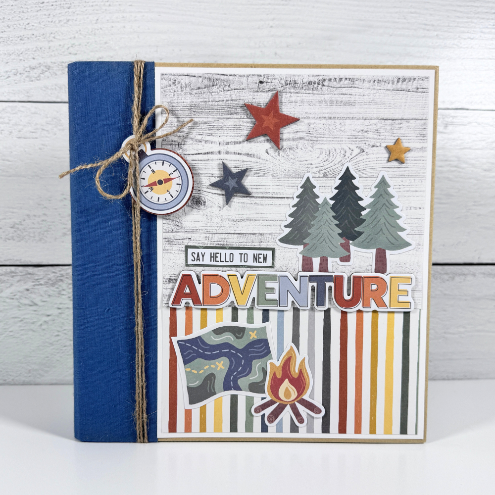 Say Hello To New Adventure Mini Scrapbook Album with trees, stars, mountains, and wood grain papers