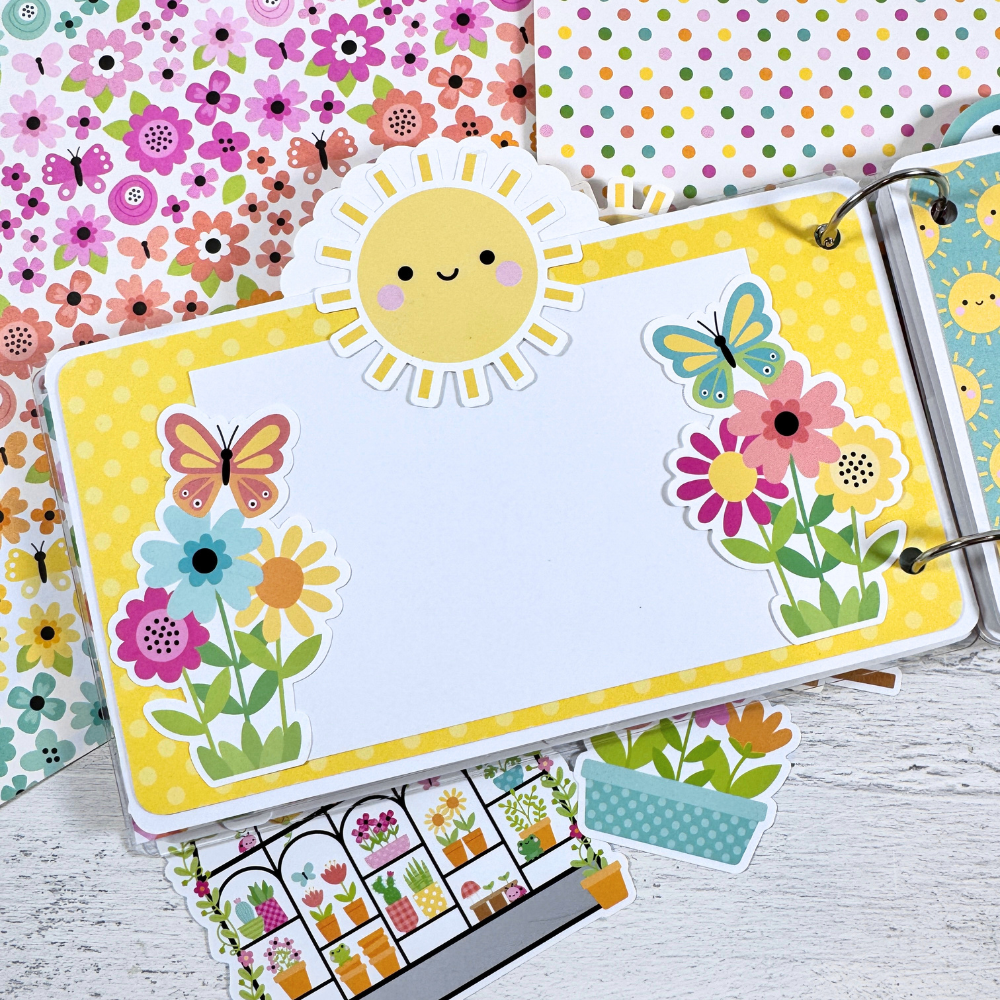 Happy Memories Scrapbook Mini Album Page with spring flowers, butterflies, a bright sun, and yellow polka dots