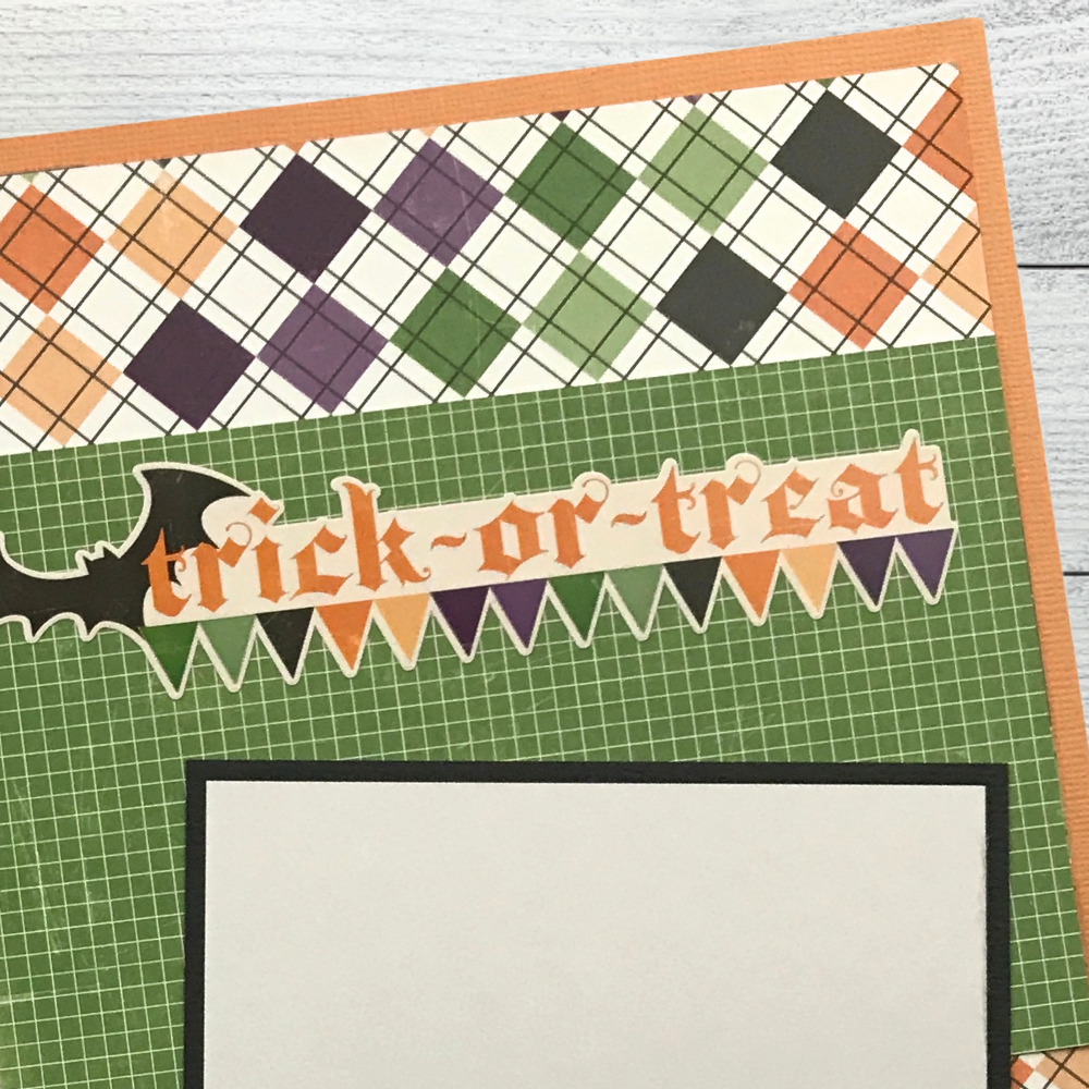 12x12 Spooktacular Halloween Scrapbook Layout with a bat, a a flag banner, and a colorful plaid paper