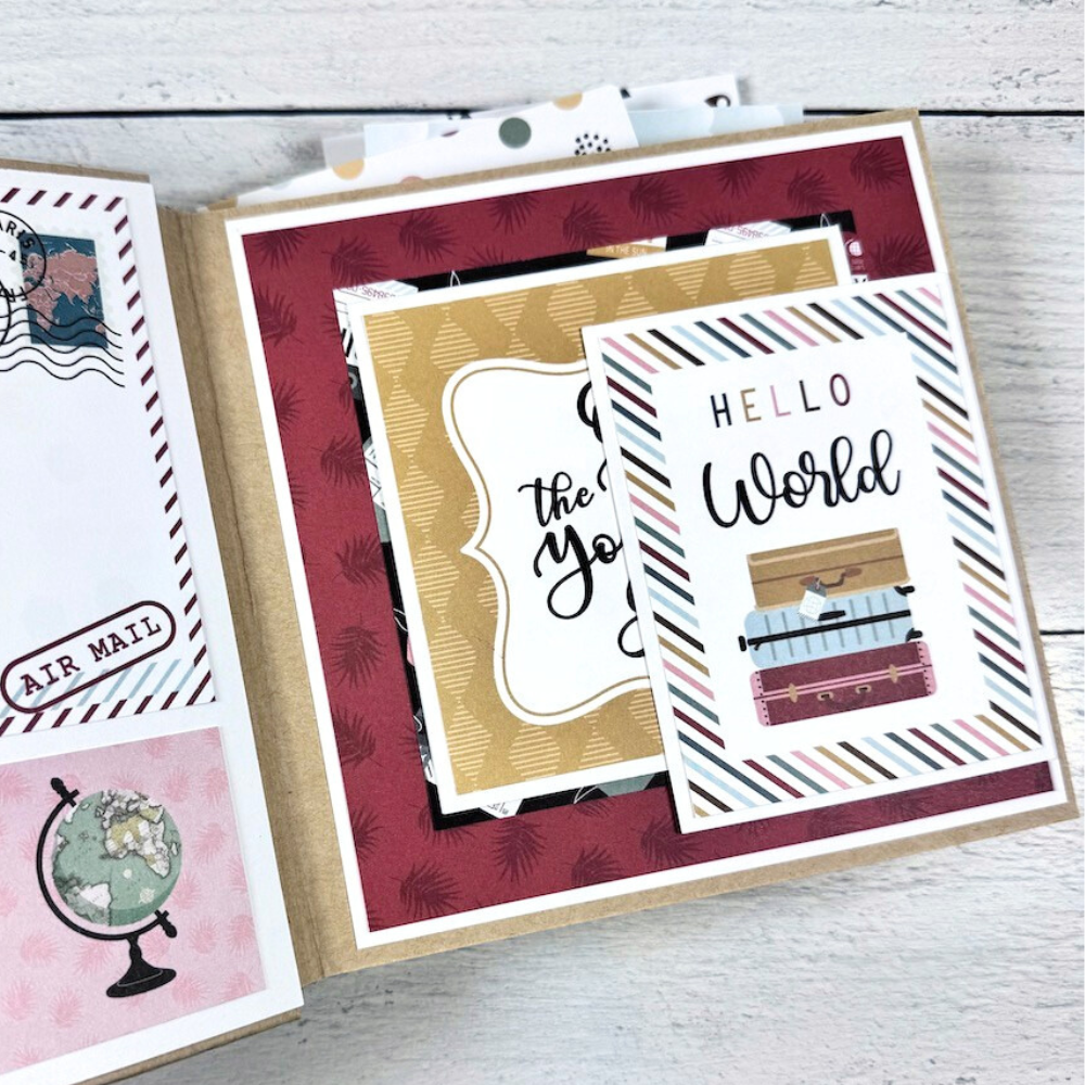 Travel The World With Me Scrapbook Album page with a globe, suitcases, a folding card, and travel stamps