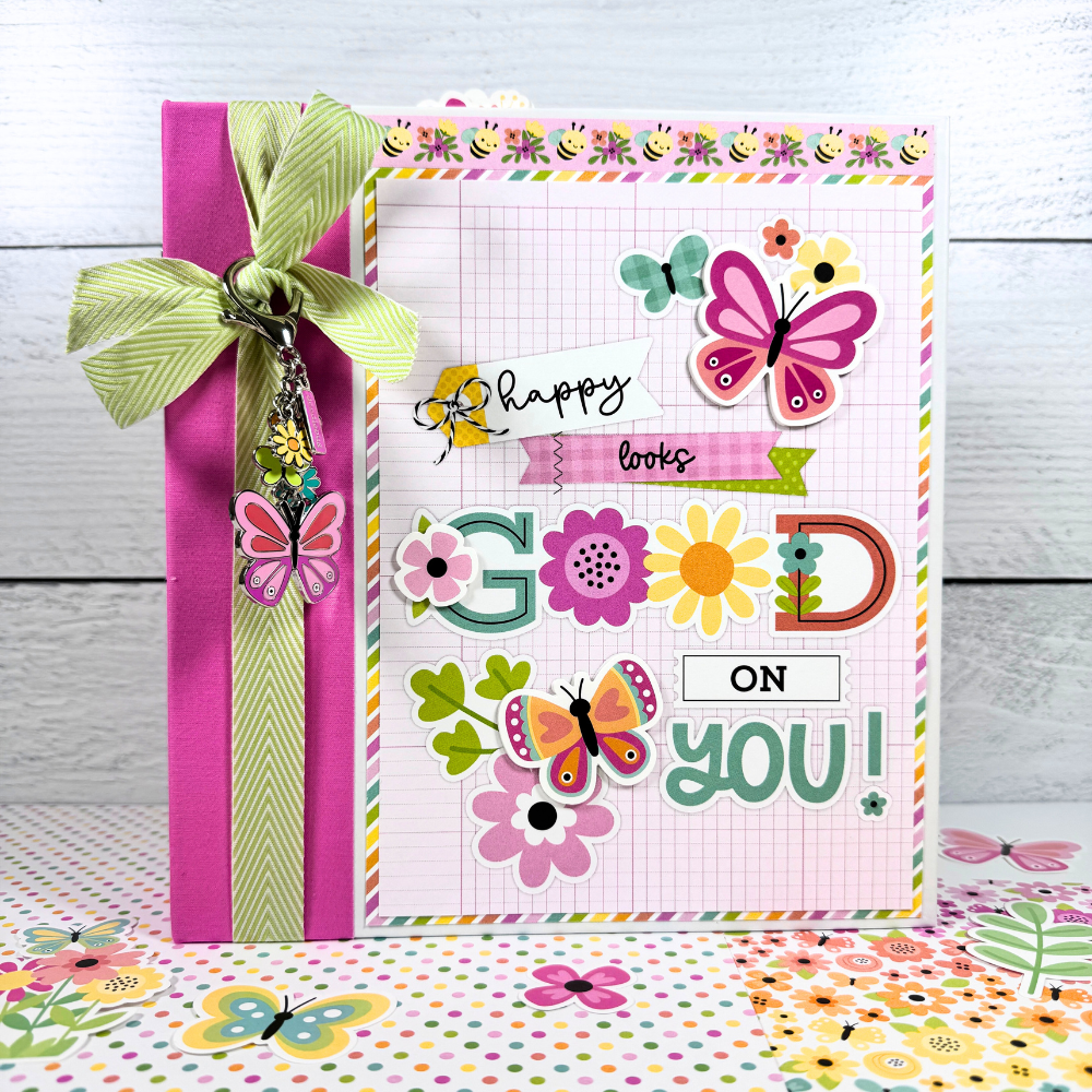 Butterfly Kisses Spring Scrapbook Mini Album with flowers, a bow, and a pretty charm