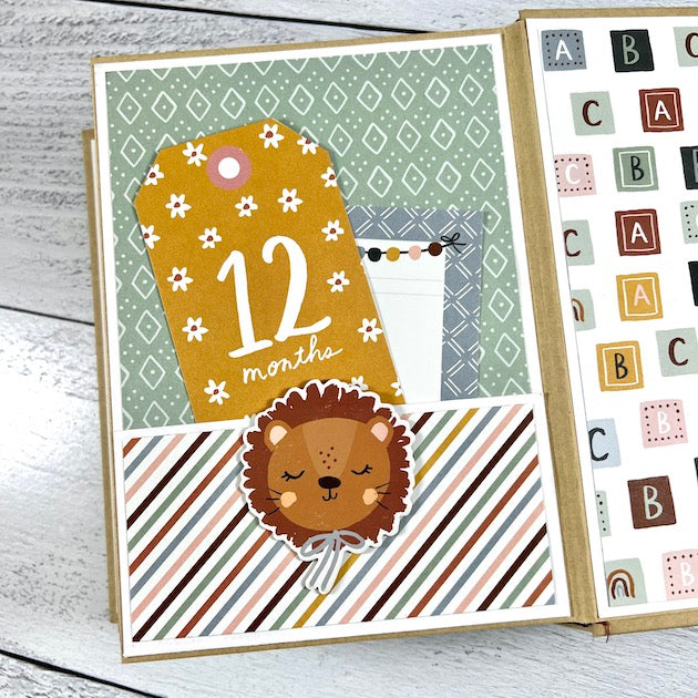 Baby scrapbook album page with a pocket, lion and stripes