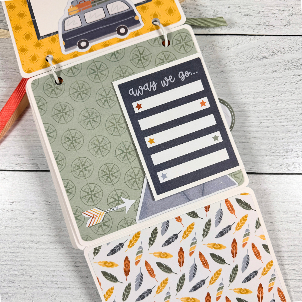 Adventure Scrapbook Mini Album Page with feathers, a cute journaling card, a van with luggage, and compasses