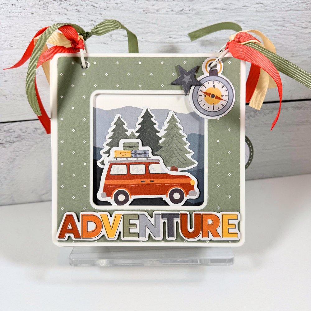 Adventure Scrapbook Album Kit by Artsy Albums displayed on a clear acrylic stand