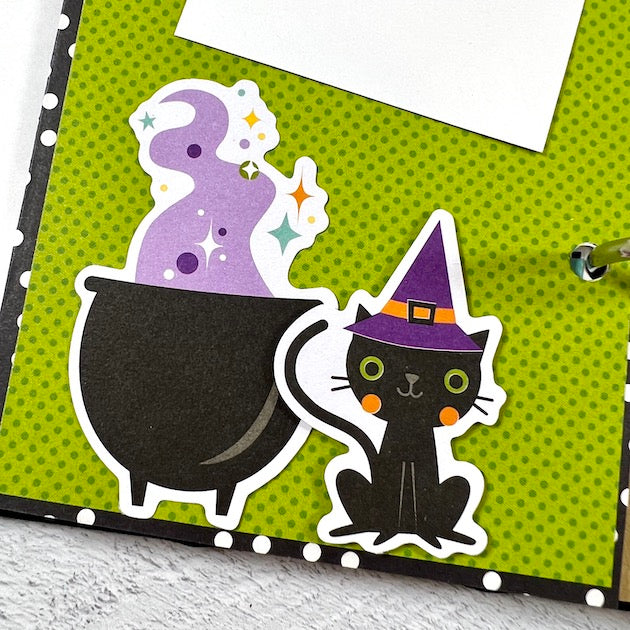 Halloween scrapbook album page with cauldron, black cat and witch's hat