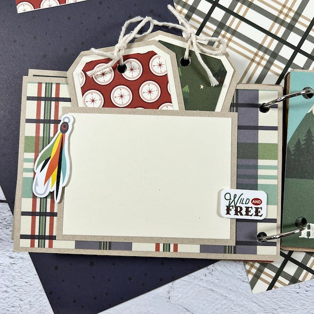 Adventure Awaits Scrapbook Album Page with a pocket, journaling cards, a fishing lure, compasses, and a colorful plaid paper