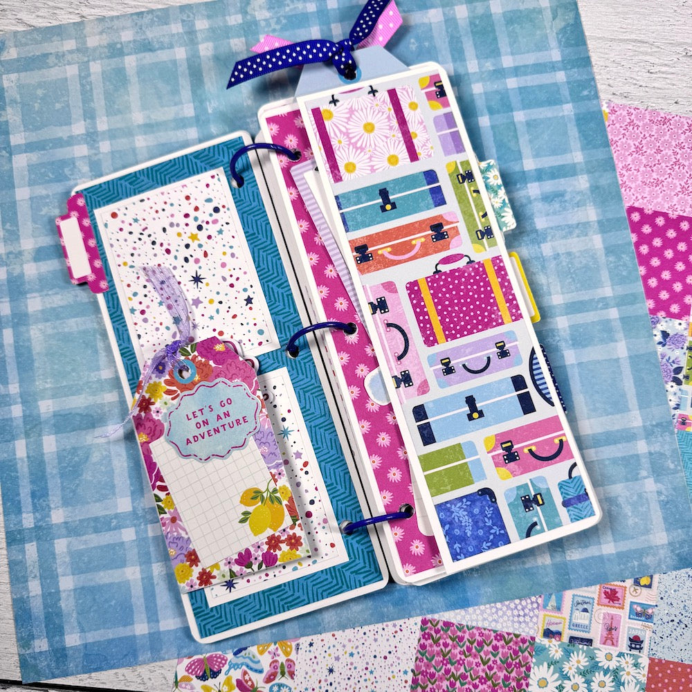 Let's Get Away Travel Scrapbook Album Page with folding element, flowers, suitcases, and a tag with ribbon