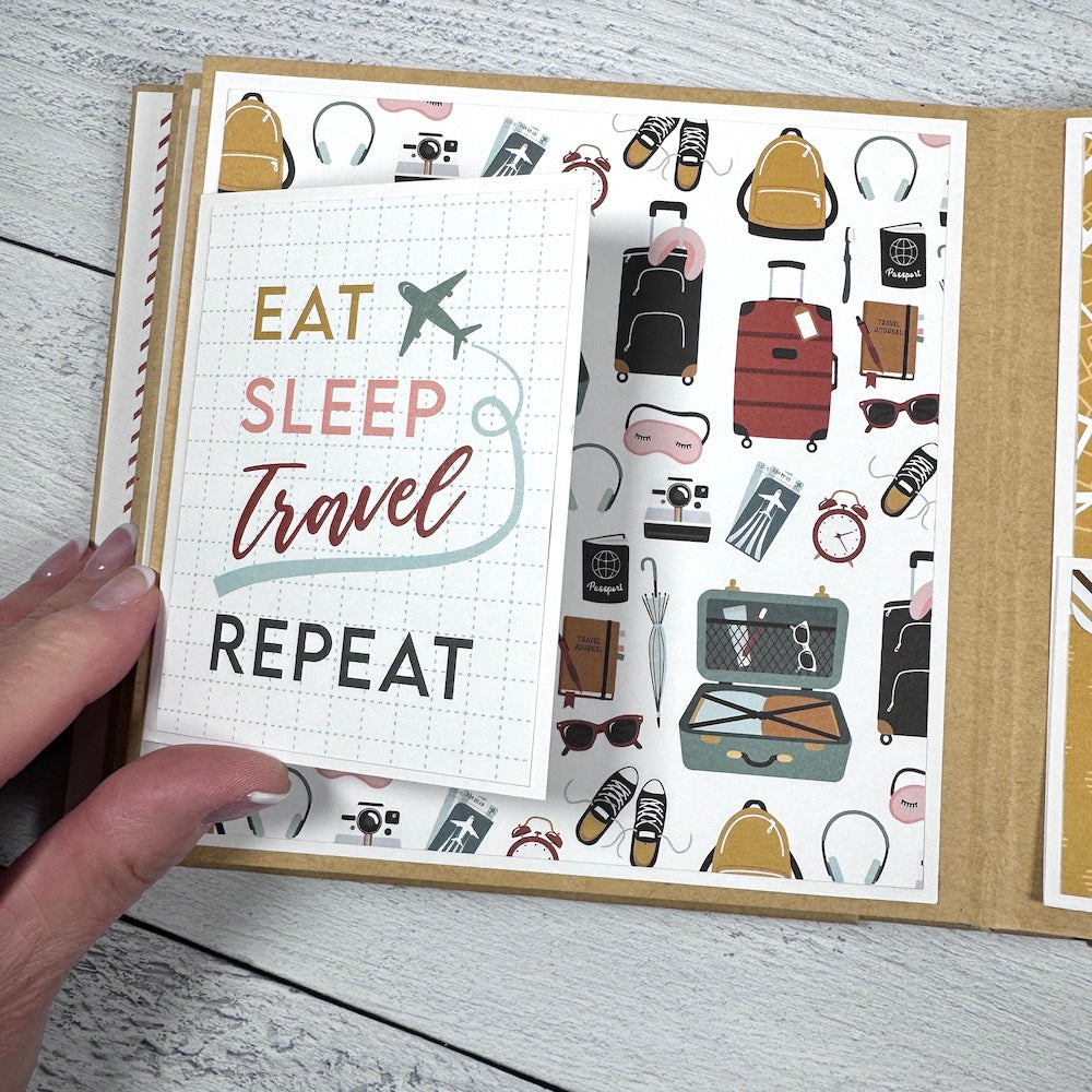 Travel The World With Me Scrapbook Album page with suitcases, sneakers, backpacks, headphones, cameras, and a folding card