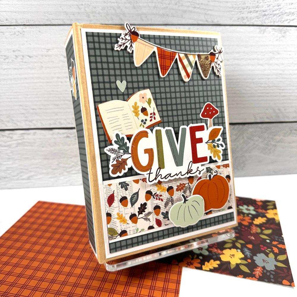 Give Thanks Fall Scrapbook Album with acorns, pumpkins, leaves, and an autumn banner displayed on a clear acrylic stand