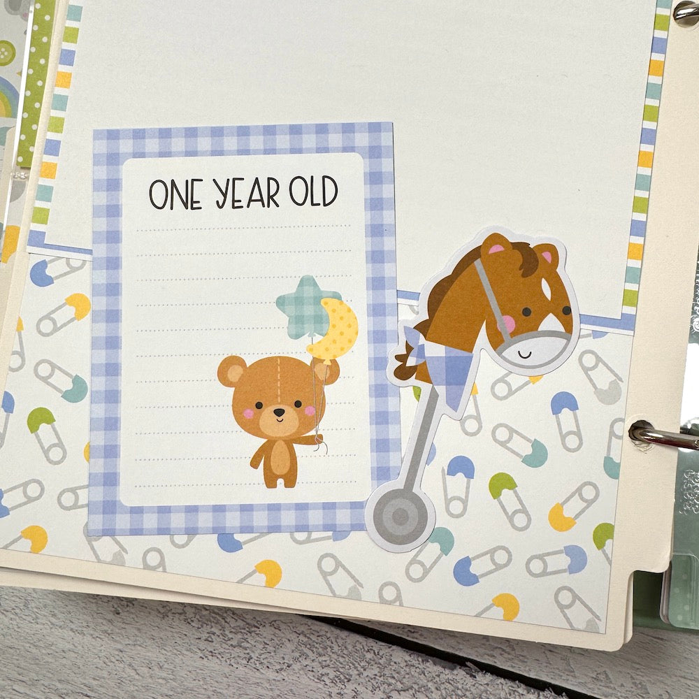 My Baby Boy Scrapbook Album page with a journaling card, a bear, balloons, a toy horse, and safety pins