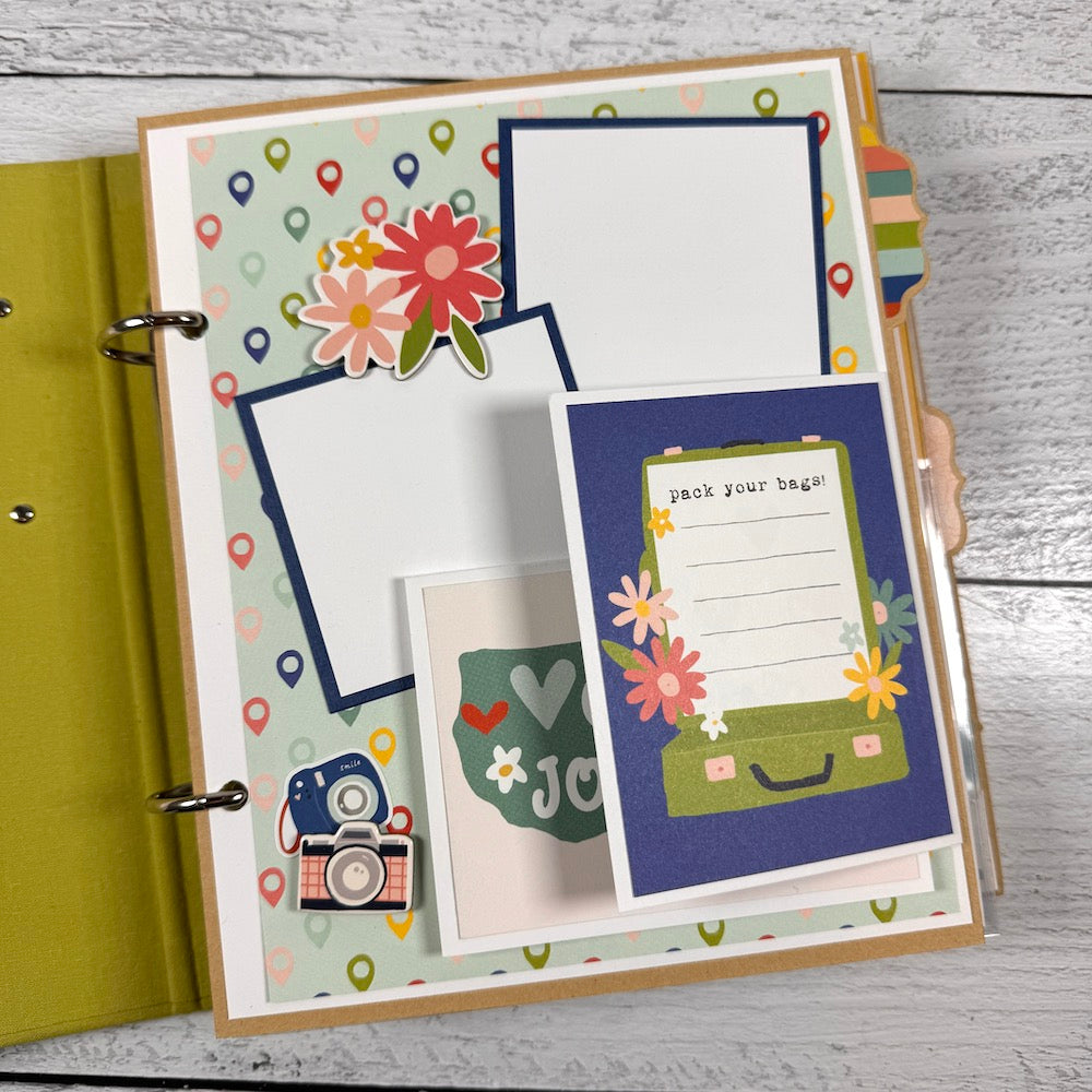 Road Trip Travel Scrapbook Album page with a folding card, flowers, luggage, and a camera