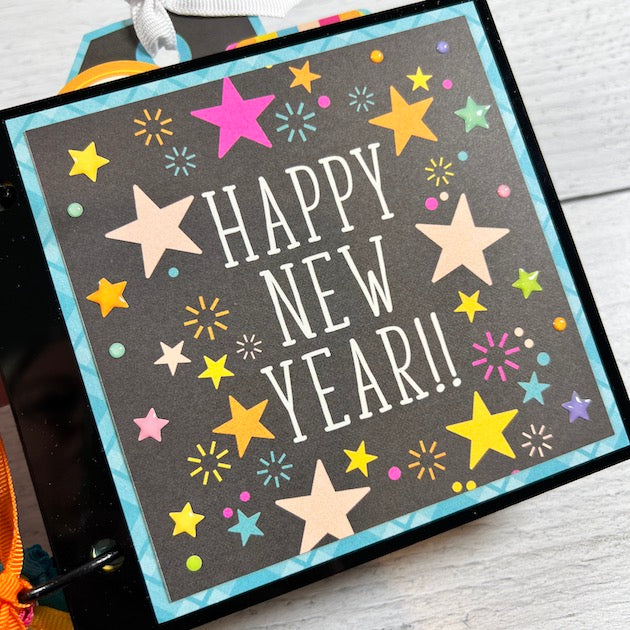 Happy New Year Scrapbook Album with stars, fireworks, and enamel stickers on the cover