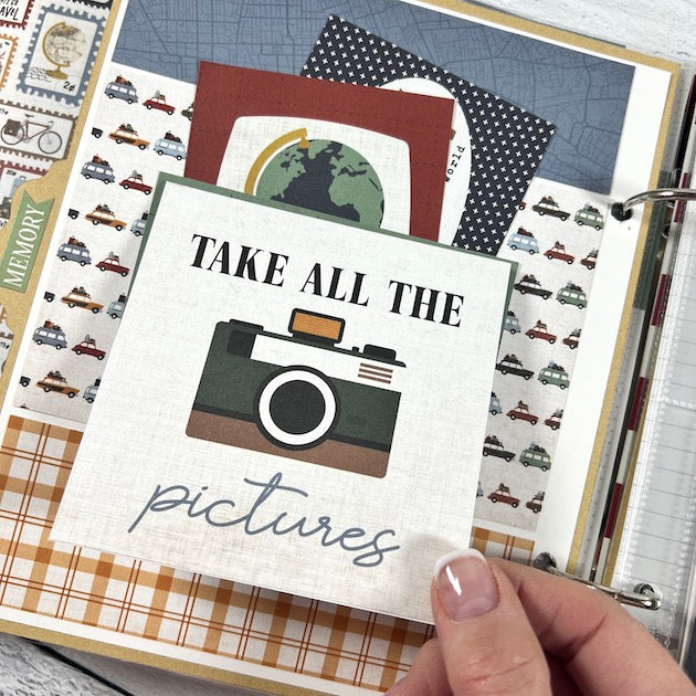 Travel The World Scrapbook Album page with cars, a camera, a pocket, and journaling cards