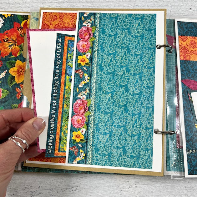 Let's Get Artsy scrapbook album page with vibrant colors, flowers, and a pocket with cards