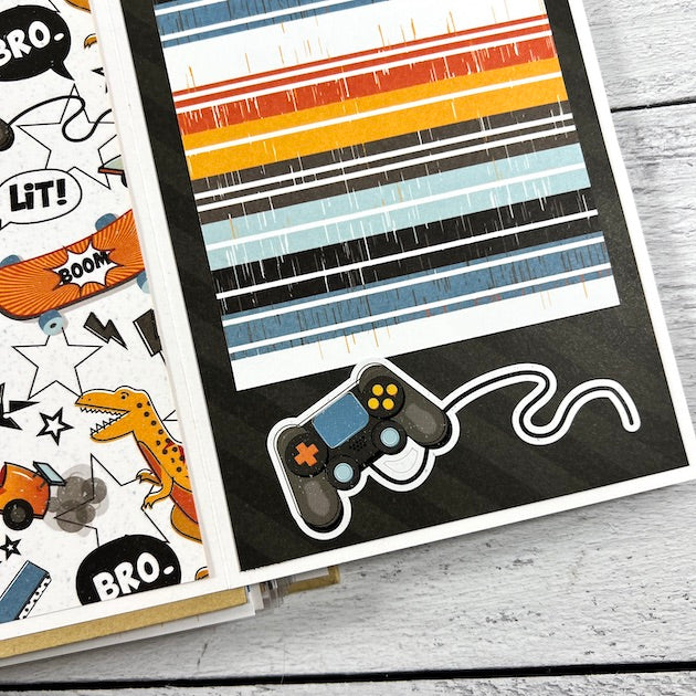 Boy Scrapbook Album page with stripes, skateboards, race cars, dinosaurs, and a video game controller