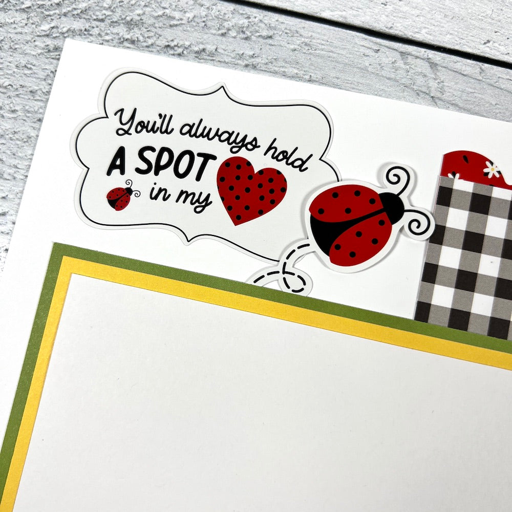 12x12 scrapbook layout with ladybugs, a heart, and a photo mat