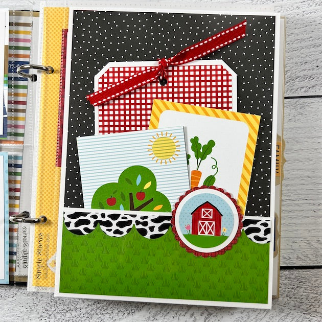 On the Farm Scrapbook Album page with a barn and a pocket filled with journaling cards & photo mats