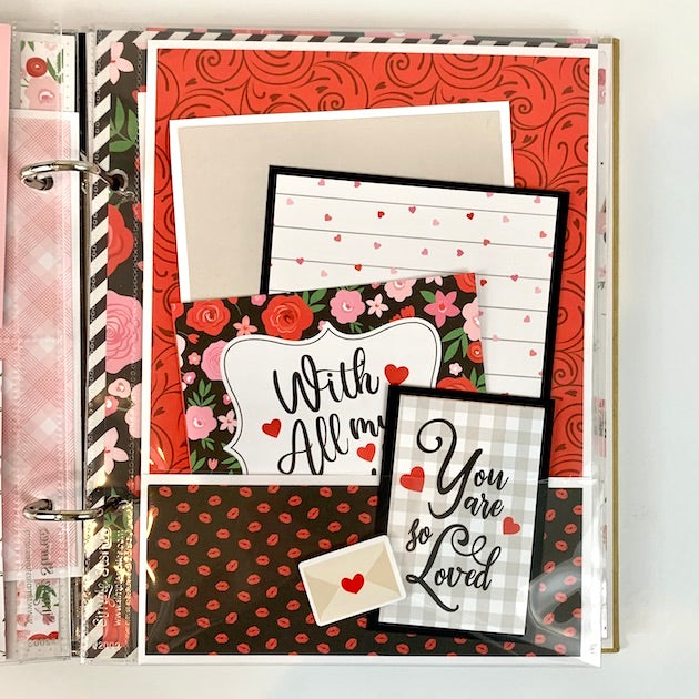 Love You More Scrapbook page with a pocket, flowers, and cute little hearts