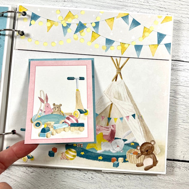 Baby Scrapbook Album Page with baby toys, a tents, banners, and twinkly lights