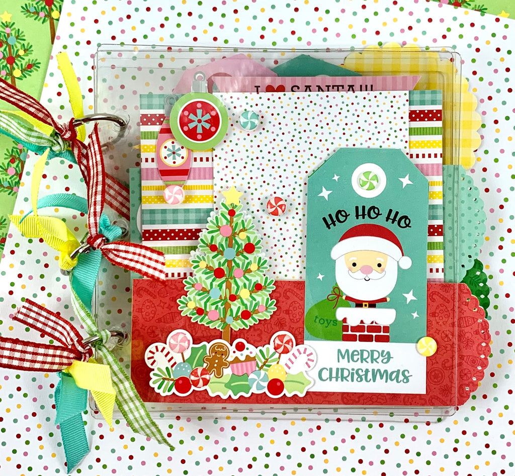 Clearly Christmas Scrapbook Mini Album with a cute Santa Claus, tree, presents, sweet treats, reindeer, and ornaments