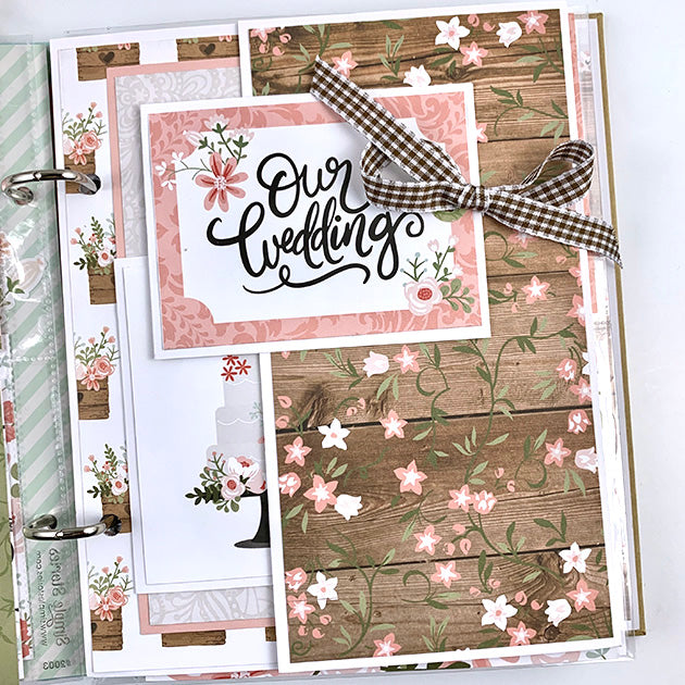 Our Wedding Day Scrapbook Album Page with lots of pretty flowers, a cake, a folding element, and woodgrain papers