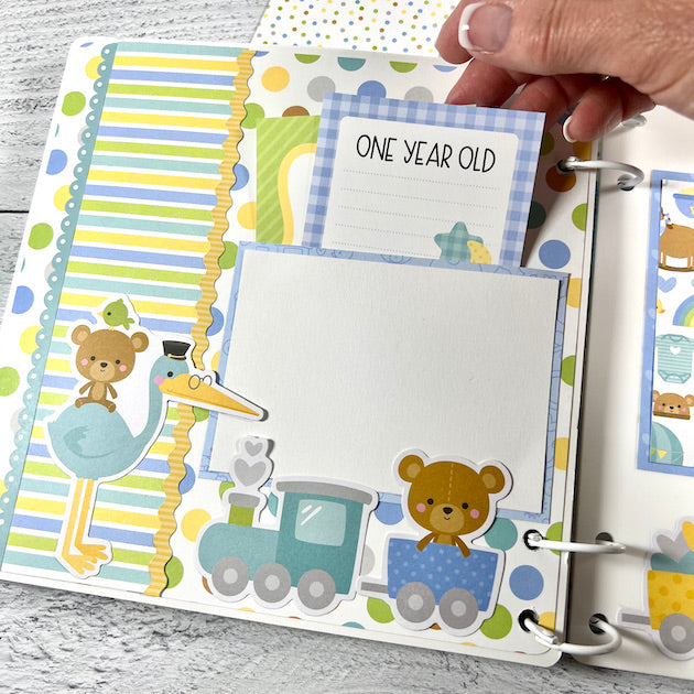 Baby boy scrapbook album page with train, stork and a pocket